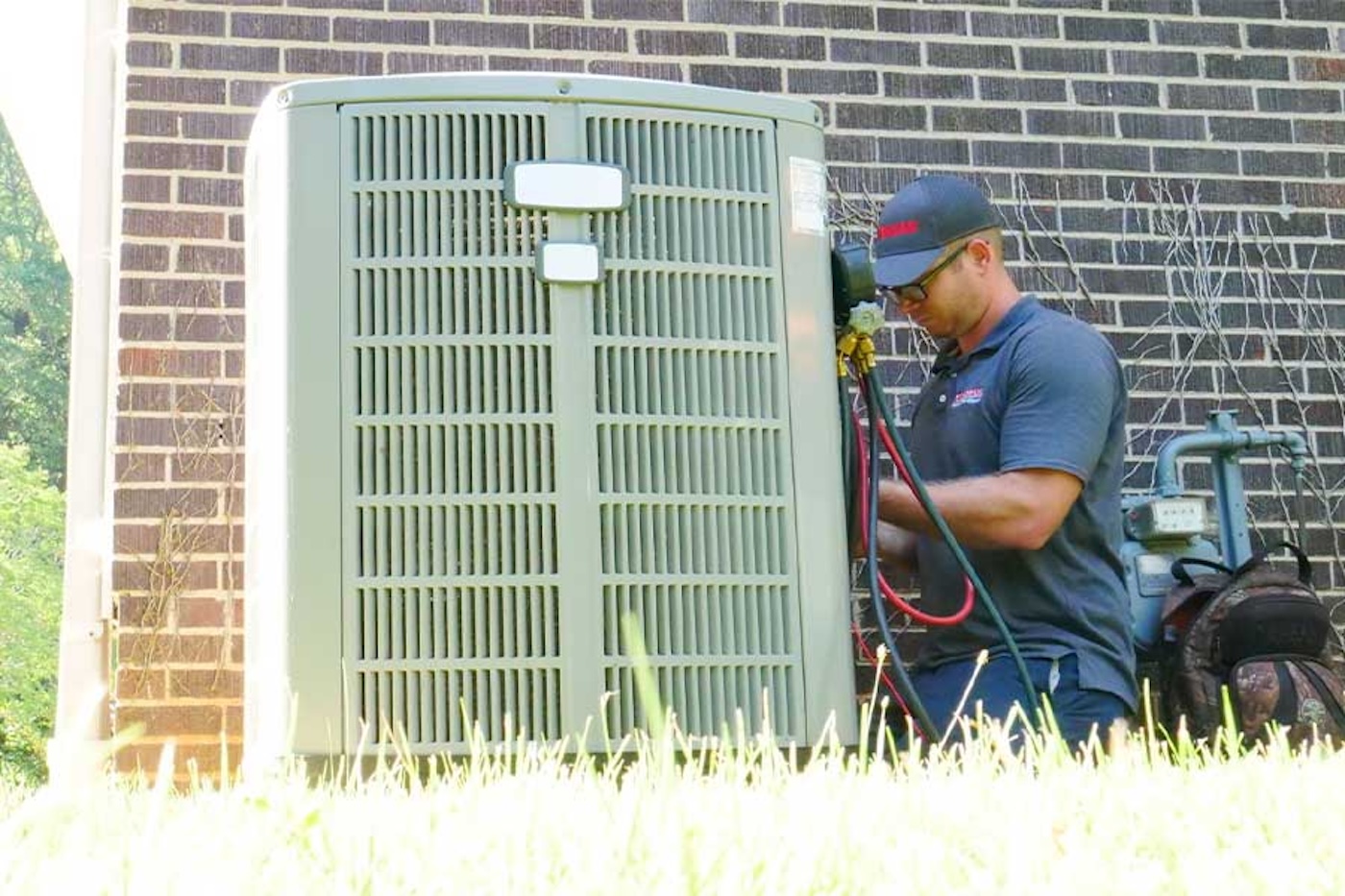 hvac technician performing maintenance on ac unit outside of home